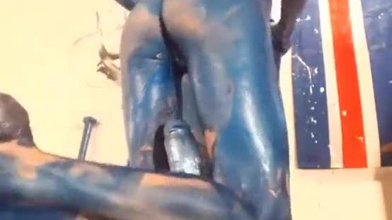Ragazza dipinda in blu sta cavalcando un enorme dildo
